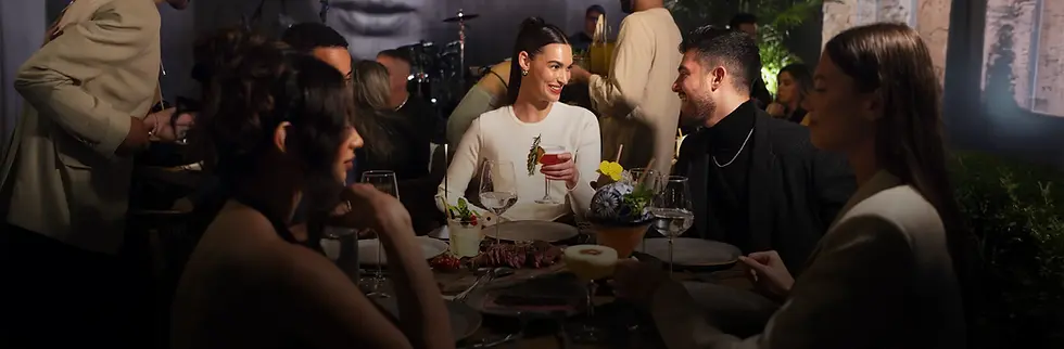 Guests dining and talking at a table at Rosa Negra Miami